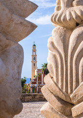 Wall Mural - Saint Peter's church seen through Statue of Faith in old town of Jaffa, Tel Aviv, Israel