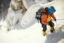 Mountaineer Clinging To A Rope On A Steep Snow-covered Mountain Slope.  Tilt-shift Effect.