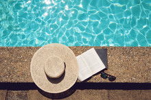 Book And Hat At The Pool Side