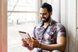 © proimagecontent - Successful bearded enterpreneur man using tablet computer for business sitting near window