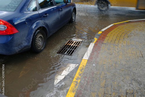 Plakat Słaba naprawa dróg. Po deszczu woda nie spływa do kanalizacji.