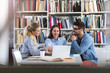 © pikselstock - University students working in the library at campus