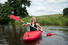 Young Woman Kayaking In River
