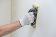 Hand smoothing out wall with sandpaper