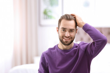 Portrait of young man with beautiful hair indoors