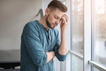 Wall Mural - Man suffering from headache at home