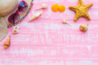 Beach accessories including sunglasses, starfish, hat beach and shell on bright pink pastel wooden background for summer holiday and vacation concept.