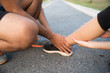 Ankle sprained. Young woman suffering from an ankle injury while exercising and running and she getting help from man touching her ankle. Healthcare and sport concept.