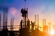 © Yuttana Studio - Silhouette of engineer and construction team working at site over blurred background sunset pastel for industry background with Light fair.
