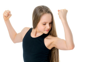 a little girl shows her muscles.