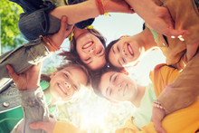 Friendship And People Concept - Group Of Happy Teenage Friends Holding Hands Outdoors