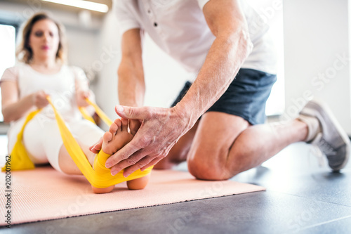 Fotografia Unrecognizable senior physiotherapist working with a female patient