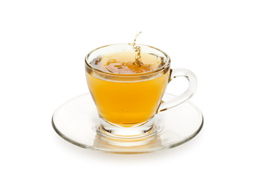 Poster - tea in glass cup with drop splashing, on white background