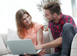 © ASDF - young man and his girlfriend looking at pictures on the laptop.