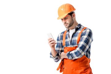 Wall Mural - workman in orange overall and hard hat using smartphone isolated on white