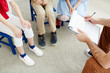 © pressmaster - Unreсognizable male teacher holding clipboard with lesson plan and communicating with kids in classroom
