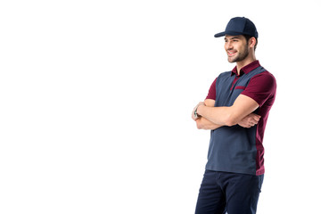 Sticker - side view of smiling delivery man in cap with arms crossed isolated on white