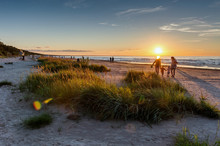 Warm Summer Sunset. Beach Landscape With Silhouettes Of People On The Background. Jurmala Resort, Latvia, Baltic Sea. Vacation Concept 