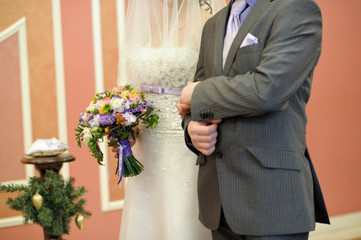 The bride and groom hold hands during the wedding ceremony. Wedding Day at the Wedding Palace.