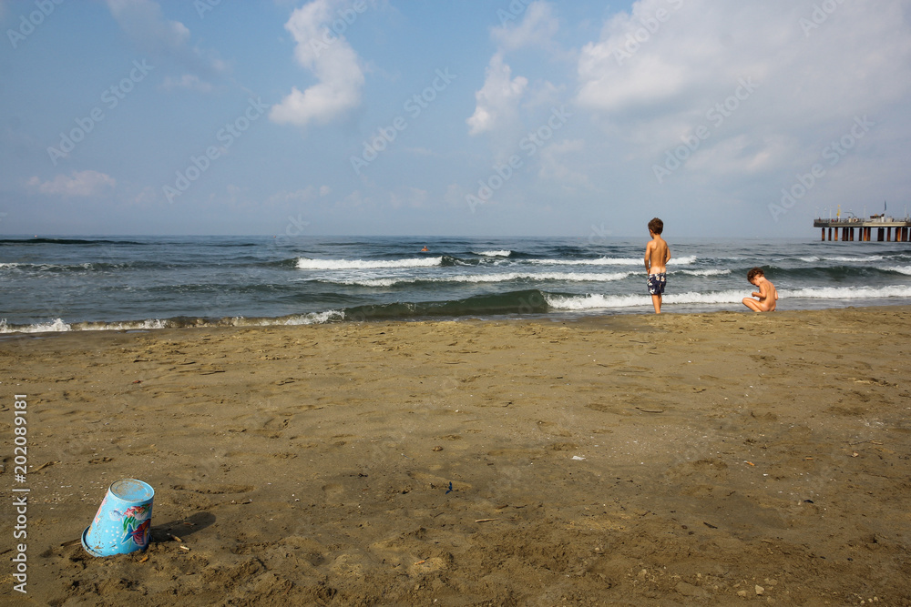 boy and girl peeing side by side on the beach looking at the sea Stock Photo Adobe Stock