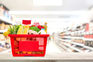 Shopping basket full of food and groceries on the table in supermarket