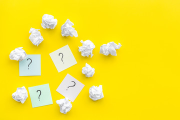 Poster - FAQ concept. Question mark on sticky notes near crumpled paper on yellow background top view copy space