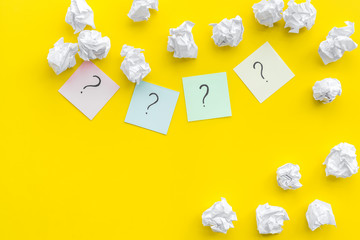 Poster - FAQ concept. Question mark on sticky notes near crumpled paper on yellow background top view copy space
