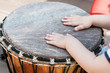  closeup of baby hands on african drums in outdoor