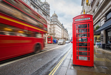 London, England - Iconic Blurred Vintage Red Double-decker Bus On The Move With Traditional Red Telephone Box In The Center Of London At Daytime
