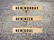 Motivational and inspirational quote. Words ‘New Monday, new week, new goal’ on wooden cloth clips. 