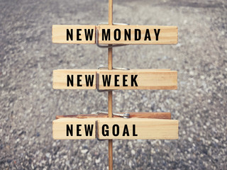 Motivational and inspirational quote. Words ‘New Monday, new week, new goal’ on wooden cloth clips. 