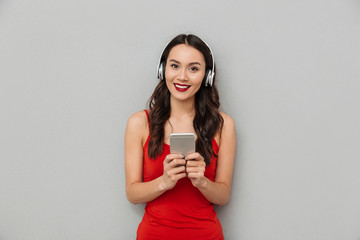 Poster - Smiling brunette woman in casual clothes and headphones listening music