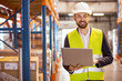 © zinkevych - Professional logistics manager. Cheerful nice man smiling while dealing with logistics system in the storehouse