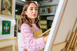 © LIGHTFIELD STUDIOS - attractive female artist painting in workshop
