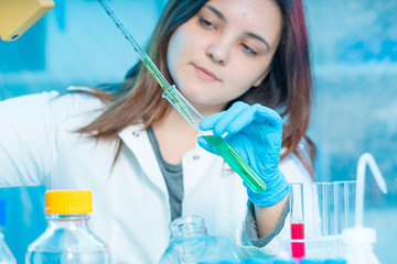 Sticker - Young attractive female scientist  load liquid sample substance probe in the scientific chemical research laboratory