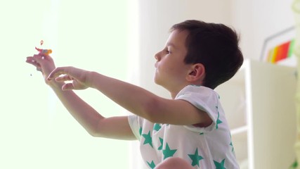 Wall Mural - childhood, imagination and dream concept - happy little boy playing with airplane toy at home