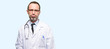 Doctor senior man, medical professional with sleepy expression, being overworked and tired isolated over blue background
