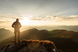 © Roman Pyshchyk - Silhouette of the man on top the peak of mountain on sunrise sky , Sport and active life conceptual design.