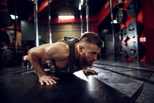 Portrait Close Up View Of Strong Motivated Muscular Bearded Short Hair Bodybuilder Man Doing Push Ups On The Floor In The Dark Gym.