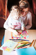 © Przemek Klos - Mom with little daughter drawing a colorful pictures using pencil crayons