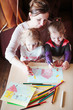 © Przemek Klos - Mom with little girls drawing a colorful pictures using pencil crayons