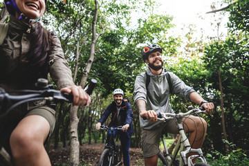 Poster - Group of friends ride mountain bike in the forest together