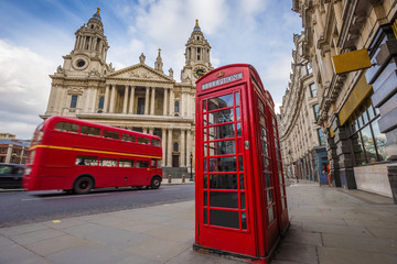 Wall Mural - London, England - Traditional red telephone box with iconic red vintage double-decker bus on the move at St.Paul's Cathedral on a sunny day