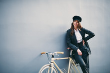 Woman Posing In Front Of Wall With Yellow Bicycle 