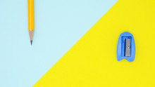 Yellow Pencil And Blue  Pencil Sharpener On Blue And Yellow  Background
