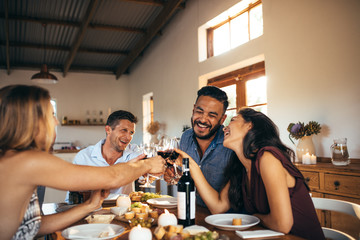 Wall Mural - Friends enjoying home party with drinks and jokes