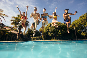 Wall Mural - Crazy young people jumping into a pool