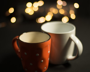 two glass cups isolated on the blurred background of LED lights. The selected focus on the edge of front cup