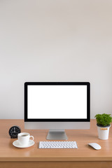 Computer all in one with plant vase and coffee cup on wooden table, Vertical Picture