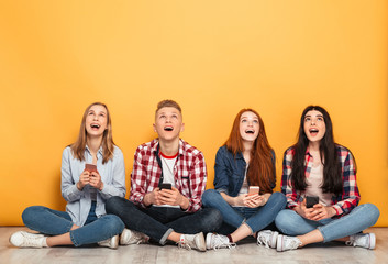 Sticker - Group of young cheerful school friends using mobile phones